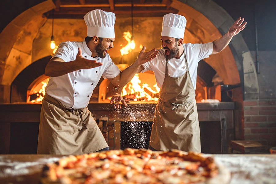 Image of pizzeria chefs arguing in the kitchen area.
