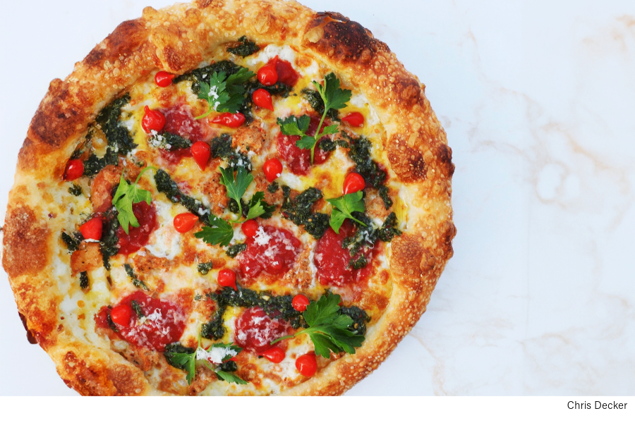 Chris Decker (EverythingbutAnchovies) shares a pizza recipe featuring Texas-style BBQ, chimichurri, Merguez sausage, sweet drop peppers, manchego cheese.