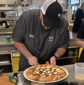 Marcus Medina pipes a seasoned cream cheese blend atop the Hellapeno Za’pper.